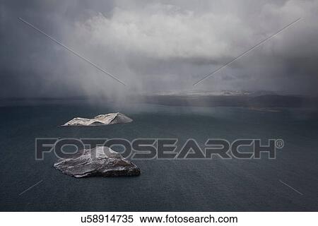 Stock Photography - Rain falling on islands in water. Fotosearch