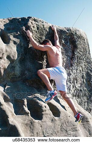 Rock climber scaling rock face View Large Photo Image Stock Image - Rock climber scaling rock face. Fotosearch