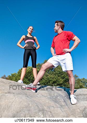 Stock Photo - Rock climbers standing on boulder. Fotosearch