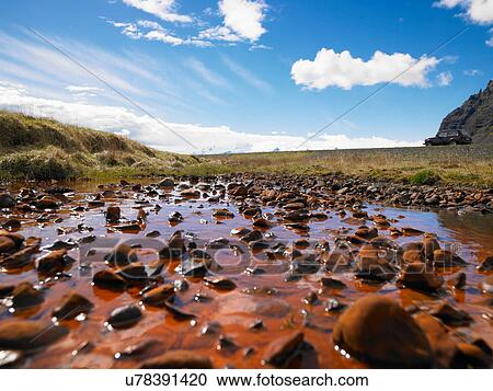 Stock Image - Rocks in rural pond. Fotosearch