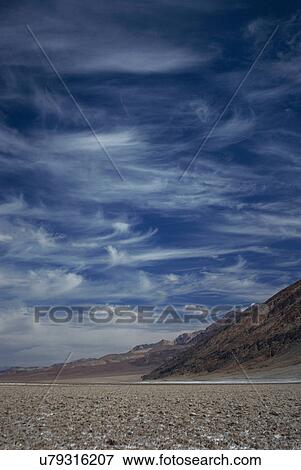 Stock Photo - Rocky rural road under cloudy sky. Fotosearch