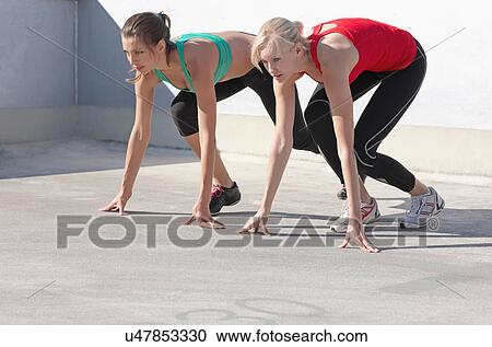 Runners crouching at start position View Large Photo Image Stock Image - Runners crouching at start position. Fotosearch
