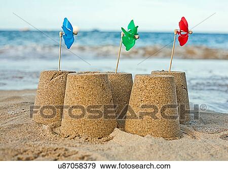 Sandcastles with pinwheels on beach View Large Photo Image Stock Photo - Sandcastles with pinwheels on beach. Fotosearch