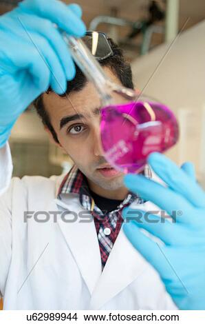 Scientist examining liquid in beaker View Large Photo Image Picture - Scientist examining liquid in beaker. Fotosearch
