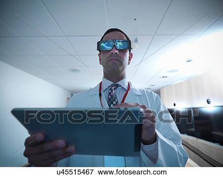 Stock Photo - Scientist wearing 3D glasses and using 3D screen. Fotosearch