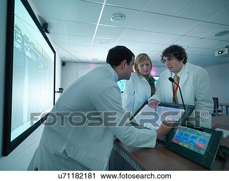 Scientists and apprentice discuss presentation in conference room View Large Photo Image Stock Image - Scientists and apprentice discuss presentation in conference room. Fotosearch