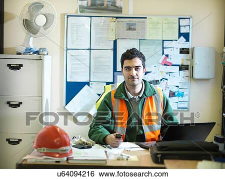 Site foreman at desk in office of building site View Large Photo Image Stock Photograph - Site foreman at desk in office of building site. Fotosearch