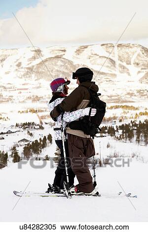 Stock Photography - Skiers hugging on mountain top. Fotosearch