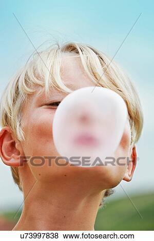 Smiling boy blowing bubble outdoors View Large Photo Image Stock Photo - Smiling boy blowing bubble outdoors. Fotosearch