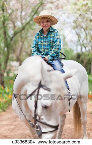 Smiling boy riding horse in park View Large Photo Image Picture - Smiling boy riding horse in park. Fotosearch