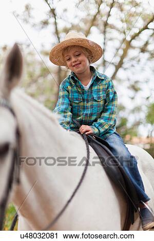 Smiling boy riding horse in park View Large Photo Image Stock Image - Smiling boy riding horse in park. Fotosearch