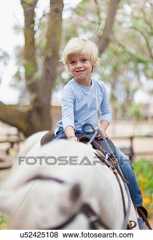 Smiling boy riding horse View Large Photo Image Stock Photo - Smiling boy riding horse. Fotosearch