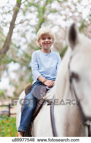 Smiling boy riding horse View Large Photo Image Stock Photo - Smiling boy riding horse. Fotosearch