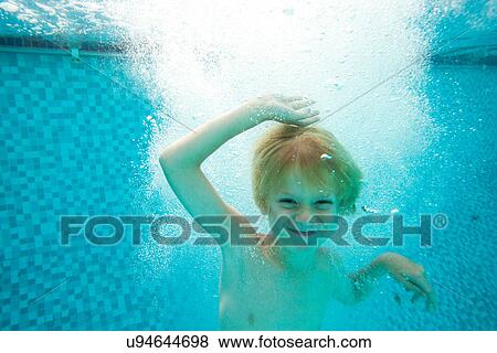 Stock Photo - Smiling boy swimming in pool. Fotosearch