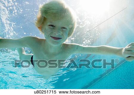 Stock Photography - Smiling boy swimming in pool. Fotosearch
