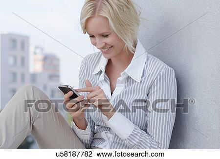 Smiling businesswoman using cell phone View Large Photo Image Stock Image - Smiling businesswoman using cell phone. Fotosearch