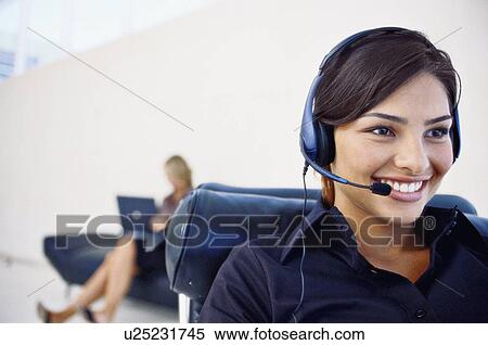 Smiling businesswoman wearing headset View Large Photo Image Stock Photography - Smiling businesswoman wearing headset. Fotosearch