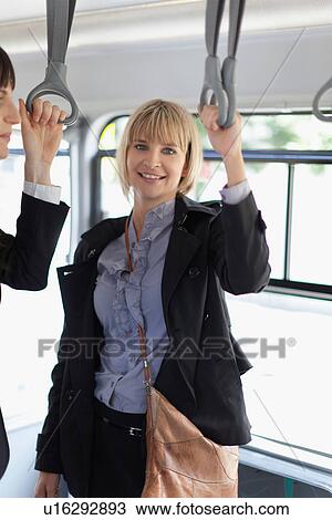 Smiling businesswomen riding the bus View Large Photo Image Stock Image - Smiling businesswomen riding the bus. Fotosearch