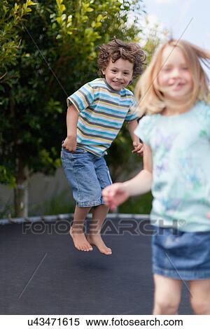 Smiling children jumping on trampoline View Large Photo Image Stock Photography - Smiling children jumping on trampoline. Fotosearch