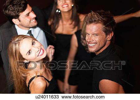 Stock Image - Smiling couple dancing in club. Fotosearch