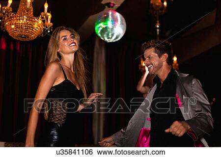 Smiling couple dancing in club View Large Photo Image Stock Photograph - Smiling couple dancing in club. Fotosearch