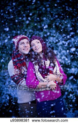 Smiling couple hugging in snow View Large Photo Image Stock Image - Smiling couple hugging in snow. Fotosearch