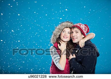 Stock Photo - Smiling couple hugging in snow. Fotosearch