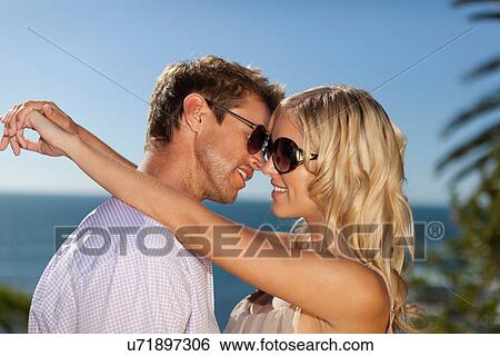 Smiling couple hugging outdoors View Large Photo Image Stock Photograph - Smiling couple hugging outdoors. Fotosearch