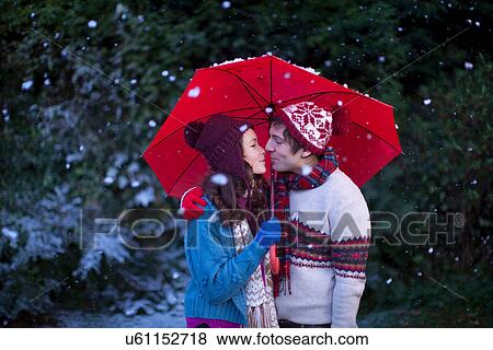 Smiling couple under umbrella in snow View Large Photo Image Stock Photo - Smiling couple under umbrella in snow. Fotosearch