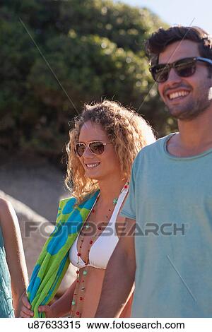 Stock Photography - Smiling couple walking on beach. Fotosearch