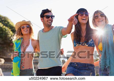 Smiling friends walking on beach View Large Photo Image Stock Photo - Smiling friends walking on beach. Fotosearch