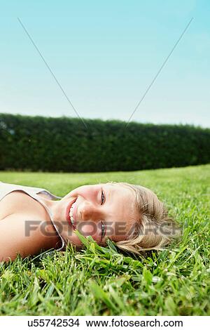 Smiling girl laying in grass View Large Photo Image Picture - Smiling girl laying in grass. Fotosearch