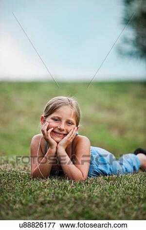 Smiling girl laying in grass View Large Photo Image Stock Photo - Smiling girl laying in grass. Fotosearch