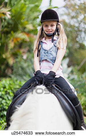 Smiling girl riding horse in park View Large Photo Image Stock Image - Smiling girl riding horse in park. Fotosearch