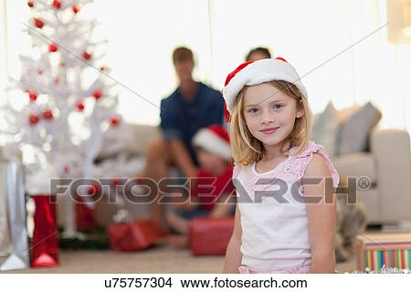 Smiling girl wearing Santa Claus hat View Large Photo Image Picture - Smiling girl wearing Santa Claus hat. Fotosearch