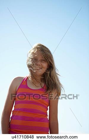 Smiling girls hair blowing in wind View Large Photo Image Stock Photo - Smiling girls hair blowing in wind. Fotosearch