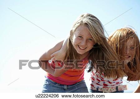 Smiling girls standing together outdoors View Large Photo Image Stock Photograph - Smiling girls standing together outdoors. Fotosearch