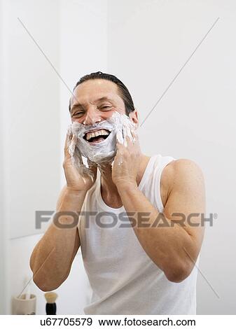 Stock Photo - Smiling man lathering his beard. Fotosearch