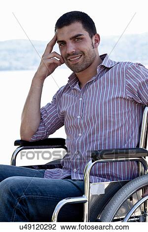 Stock Image - Smiling man sitting in wheelchair. Fotosearch