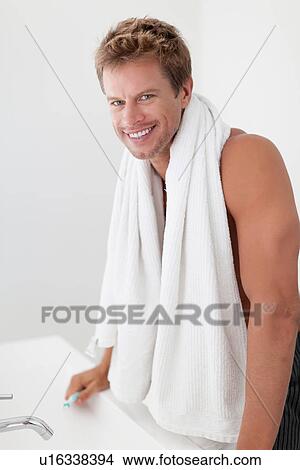 Smiling man with towel in bathroom View Large Photo Image Picture - Smiling man with towel in bathroom. Fotosearch