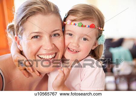 Stock Photo - Smiling mother and daughter hugging. Fotosearch