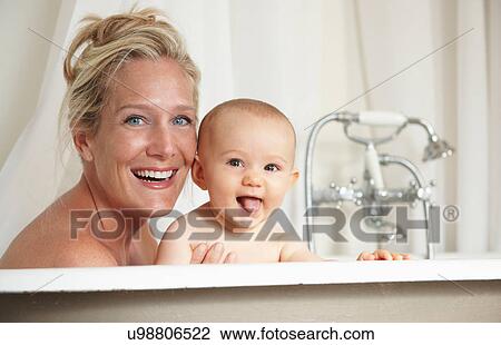 Stock Image - Smiling mother bathing with baby. Fotosearch