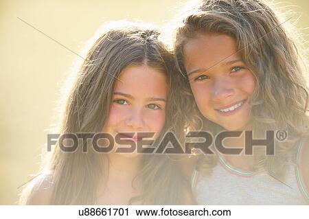 Smiling sisters hugging outdoors View Large Photo Image Stock Image - Smiling sisters hugging outdoors. Fotosearch
