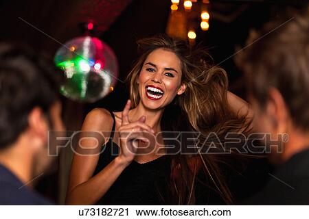 Stock Image - Smiling woman dancing in club. Fotosearch