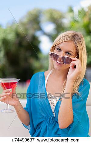 Smiling woman having cocktail outdoors View Large Photo Image Stock Photo - Smiling woman having cocktail outdoors. Fotosearch