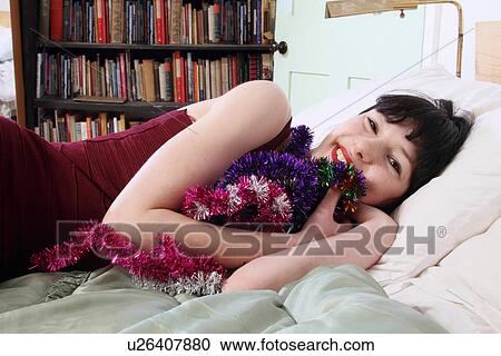 Smiling woman hugging tinsel in bed View Large Photo Image Stock Image - Smiling woman hugging tinsel in bed. Fotosearch