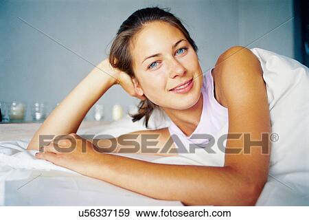 Smiling woman laying on bed View Large Photo Image Stock Photo - Smiling woman laying on bed. Fotosearch