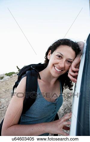 Smiling woman leaning on car View Large Photo Image Stock Photography - Smiling woman leaning on car. Fotosearch