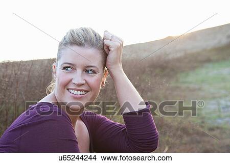 Smiling woman sitting in wheat field View Large Photo Image Picture - Smiling woman sitting in wheat field. Fotosearch