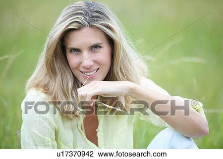 Smiling woman sitting in wheat field View Large Photo Image Stock Image - Smiling woman sitting in wheat field. Fotosearch